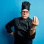 Middle age handsome grey-haired chef man wearing cooker uniform and hat Doing Italian gesture with hand and fingers confident expression