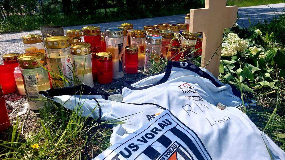 Ein Kreuz, Kerzen und ein Fußball-Trikot an der Unfallstelle