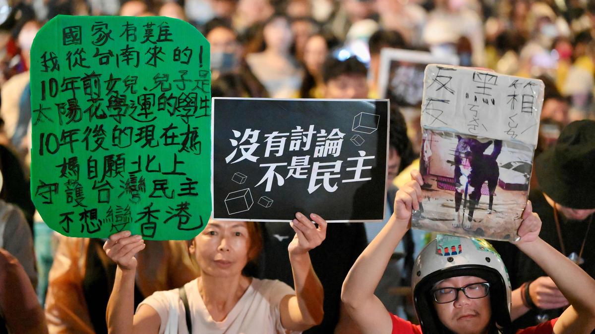 Anhänger der regierenden Demokratischen Fortschrittspartei (DPP) zeigen ein Plakat mit der Aufschrift „Keine Diskussion, keine Demokratie“, nachdem das Gesetz zur Parlamentsreform vor dem Parlament in Taipeh verabschiedet wurde.