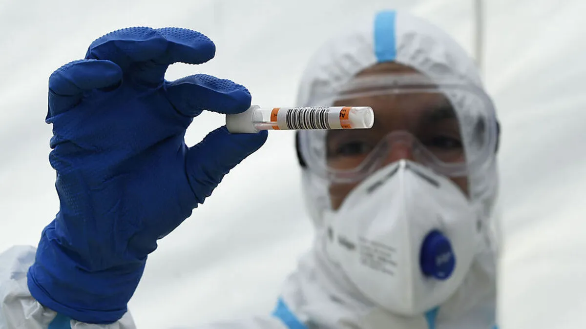 Für die Abnahme eines Coronatests muss extra Schutzkleidung angelegt werden