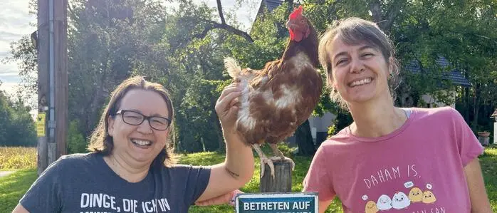 Angelika Höller-Schmitt (links) und Britta Schmitt mit Heidi: Die Henne aus einem Legebetrieb hat nur noch einen Flügel, genießt ihr Leben bei den beiden aber dennoch sichtlich