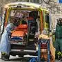Paramedics with protective gas masks help to transport a patient on April 6, 2020 in Stockholm, during the novel coronavirus Covid-19 pandemic. (Photo by Jonathan NACKSTRAND / AFP)