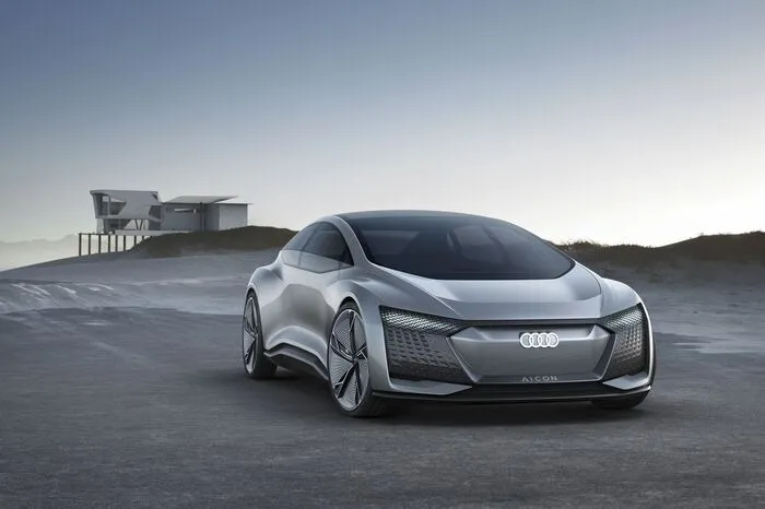 Mit der viertürigen Design-Vision Aicon stellt die Marke mit den vier Ringen einen völlig autonom fahrenden Audi der Zukunft vor – ohne Lenkrad, ohne Pedalerie. Vor dem Fahrer findet sich statt eines Armaturenbretts eine großzügige Ablagefläche und das Zentraldisplay unterhalb der Frontscheibe.
