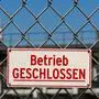 Hinweisschild an Maschendrahtzaun vor Betriebsgelände: Betrieb geschlossen. Hinweisschild an Maschendrahtzaun vor Betriebsgelände: Betrieb geschlossen. *** Sign on wire mesh fence in front of premises Operation closed Sign on wire mesh fence in front of premises Operation closed