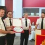 Vier Feuerwehrmänner halten eine Auszeichnung in der Hand 