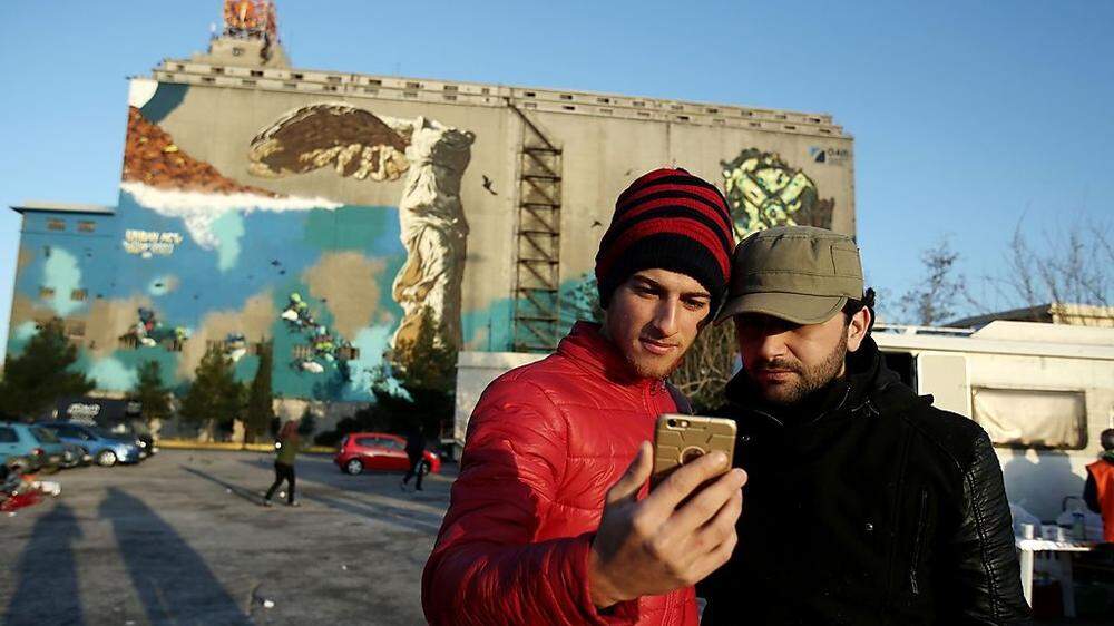 Afghanische Flüchtlinge machen nach ihrer Ankunft in Piräus ein Selfie