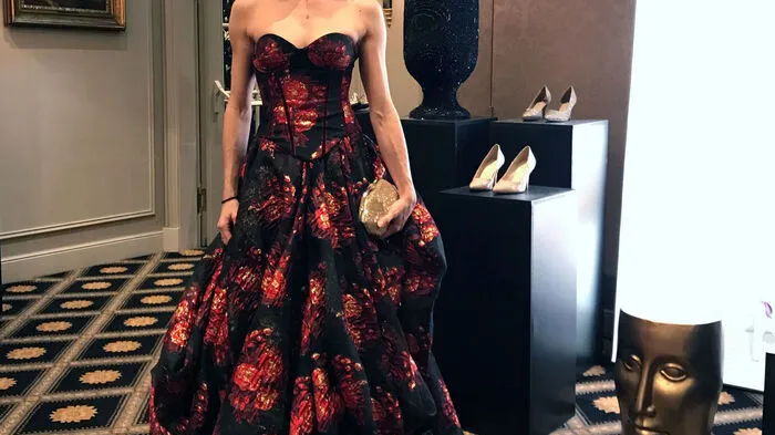 Alice Firenze, Solotänzerin der Wiener Staatsoper, in einer dreiteiligen Couture Robe in Rot, Schwarz, Gold. Die mit Samtbändern veredelte Korsage wird über den weiten Rock getragen – ganz nach dem Motto „Feel like a Princess“.