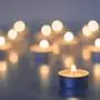 Flame of many candles burning on the background in blue and yellow color