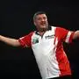 Austria's Mensur Suljovic reacts during his match against England's Luke Littler on day 14 of the Paddy Power World Darts Championship at the Alexandra Palace, London, Saturday, Dec. 27, 2025. (Steven Paston/PA via AP)