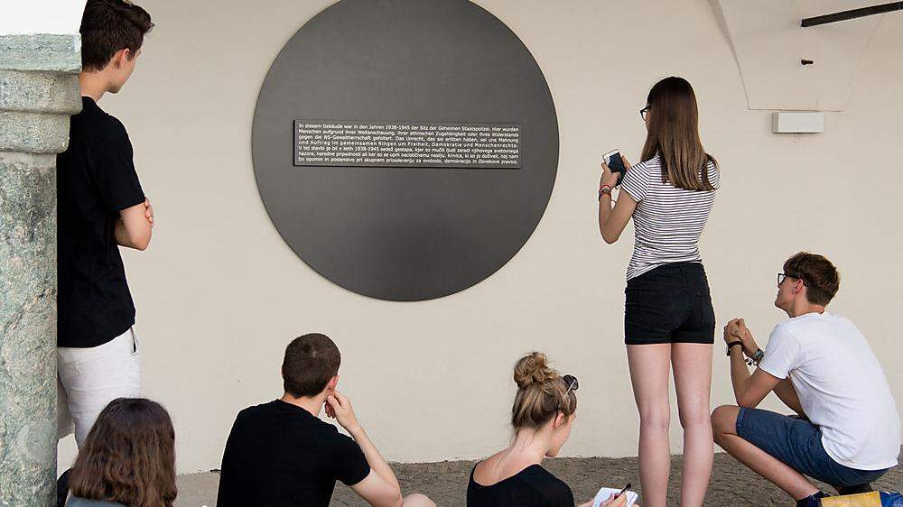 Schüler setzen sich mit dem Gedenkstein im Klagenfurter Burghof auseinander. Erinnerungsorte sind in Kärnten vielerorts zu finden