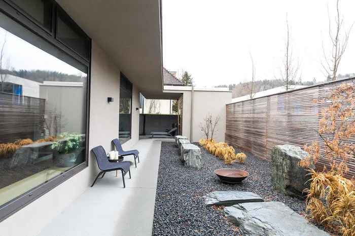 Mit einem kleinen Garten auf der Nordseite geht man auf  angenehme Distanz zur Straße. Im Hintergrund die Sauna.
