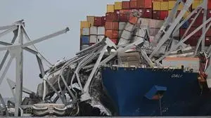 The steel frame of the Francis Scott Key Bridge sits on top of the container ship Dali after the bridge collapsed, Baltimore, Maryland, on March 26, 2024. The bridge collapsed early March 26 after being struck by the Singapore-flagged Dali, sending multiple vehicles and people plunging into the frigid harbor below. There was no immediate confirmation of the cause of the disaster, but Baltimore's Police Commissioner Richard Worley said there was "no indication" of terrorism. (Photo by Jim WATSON / AFP)