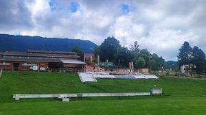 Der gesperrte Sportplatz mit der abgerissenen Volksschule im Hintergrund