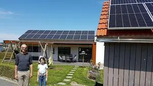 Mario Pisano (mit Tochter Daria) vor seinem Haus und dem Nebengebäude auf dem sich zahlreiche Sonnenstrom-Module befinden 