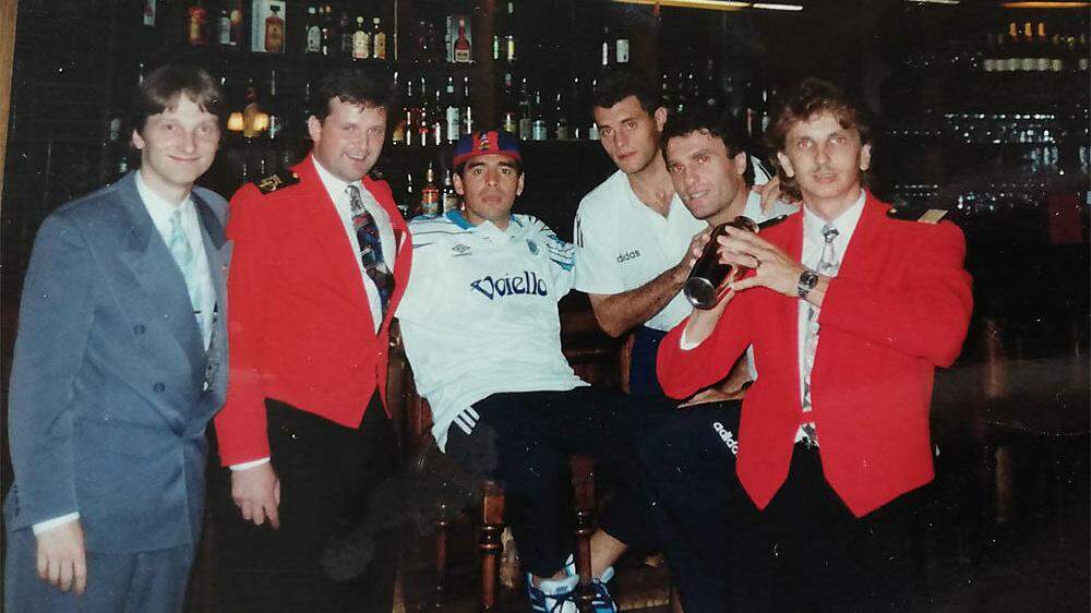 Gruppenfoto mit Maradona an der Bar: Serviceleitung Erwin Schurtl (Zweiter von links) und Restaurantfachmann Andreas Apounik (Erster von rechts) sind immer noch im Parkhotel tätig