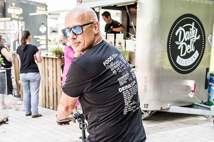 Verkaufstrick. Sigi Goufas hat seine Speisekarte auf den Rücken seines T-Shirts gedruckt.