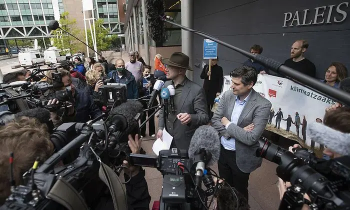 Milieudefensie director Donald Pols, center with hat, and lawyer Roger Cox, right, talk to the press after the verdict in the court case of Milieudefensie, the Dutch arm of the Friends of the Earth environmental organization, against Shell in The Hague, Netherlands, Wednesday, May 26, 2021. In a landmark legal battle of climate change activists in the Netherlands energy giant Shell was ordered to rein in its carbon emissions. (AP Photo/Peter Dejong)
