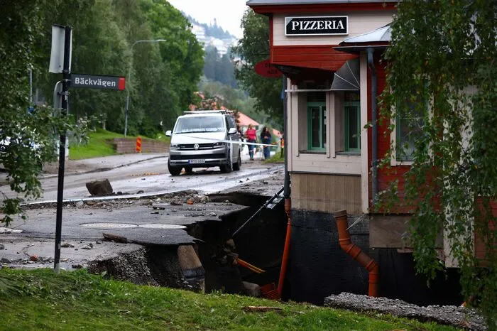 Der Fluss Susa in Nordschweden ist über die Ufer getreten. Eine zerstörte Straße und ein großes Loch im Boden vor einem Restaurant sind die Folgen.