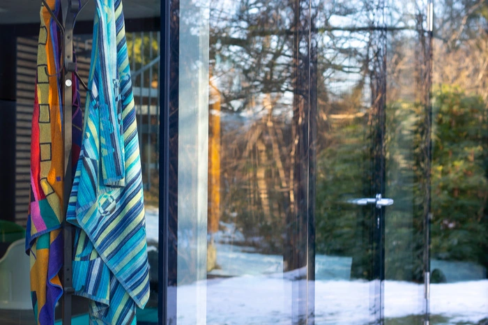 Der Poolbereich ist von Fensterfronten umgeben, eine Glastür führt zur Küche.