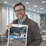 Mann mit Brille hält einen Kalender in die Kamera
