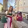 Eine junge Frau im Dirndl mit mehreren gehäkelten Taschen