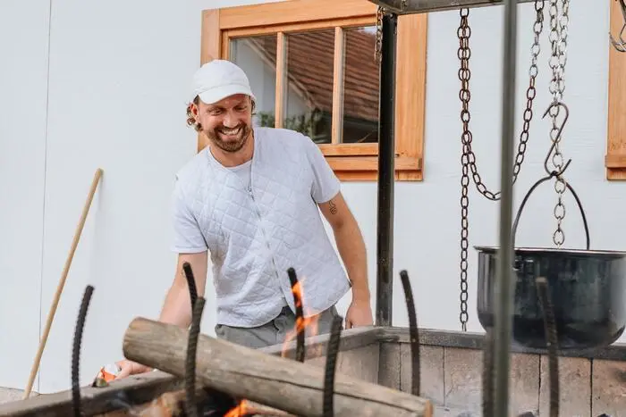 Am Weingut Locknbauer bereitet Koch Peter König Feuer fürs spätere Grillen der Fischwürste vor.
