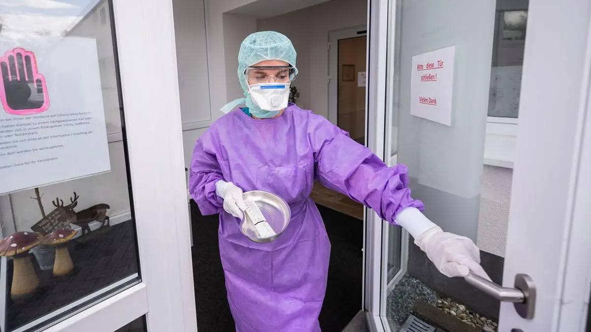 ABD0124_20200304 - GROSS-GERAU - DEUTSCHLAND: dpatopbilder - 04.03.2020, Hessen, Groß-Gerau: Roxana Sauer, Ärztliche Leiterin des Medizinischen Versorgungszentrum (MVZ), geht mit Abstrichbesteck aus dem MVZ. Bei Verdacht einer Infektion mit dem Coronavirus können sich Patienten in der Stadt im eigenen Auto untersuchen lassen. Das Medizinisches Versorgungszentrum (MVZ) an der Kreisklinik Gross-Gerau nimmt seit dem Wochenende auch Abstriche durch das Autofenster. Foto: Andreas Arnold/dpa +++ dpa-Bildfunk +++. - FOTO: APA/dpa/Andreas Arnold