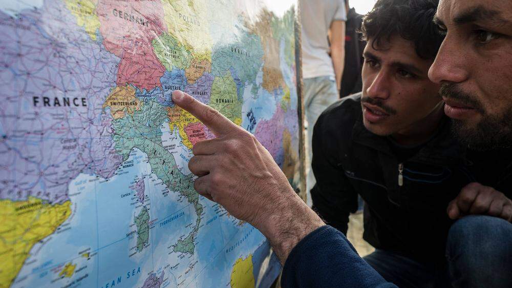 Flüchtlinge betrachten eine Europa-Karte | Für viele Flüchtlinge ist Österreich ein Durchreiseland