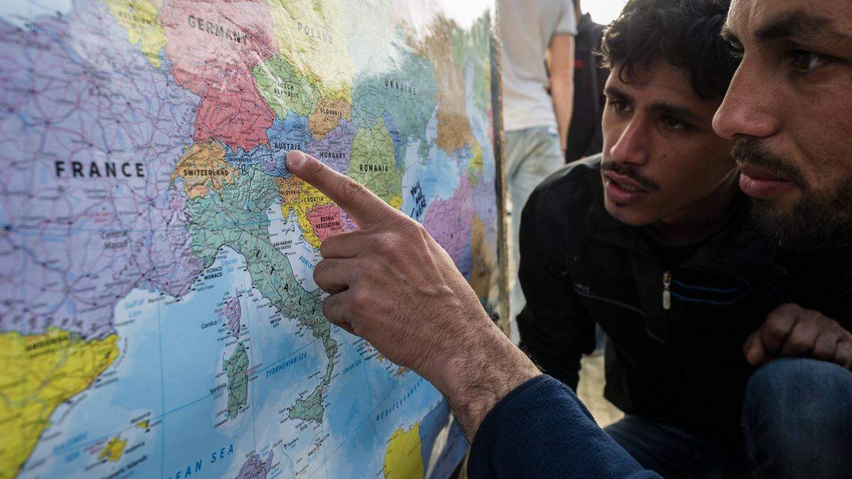 Flüchtlinge betrachten eine Europa-Karte | Für viele Flüchtlinge ist Österreich ein Durchreiseland