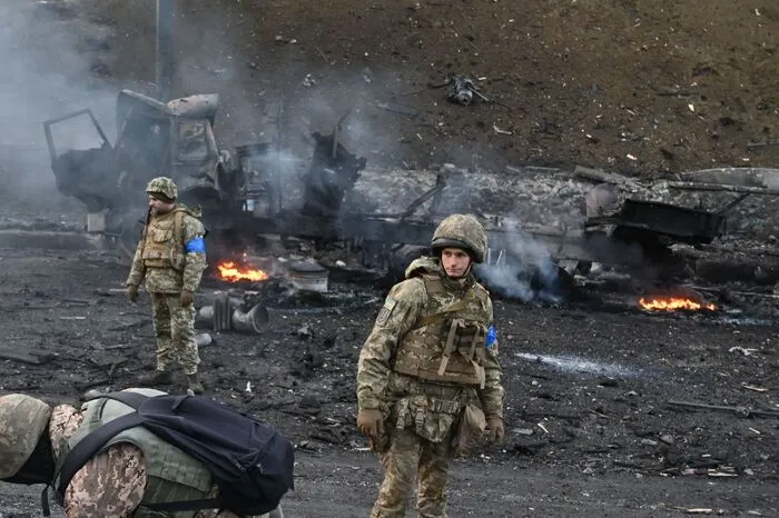 Ukrainische Soldaten inspizieren ausgebrannte russische Militärfahrzeuge. 