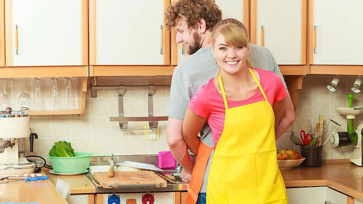 People, housework and housekeeping concept. Couple doing the washing up together in kitchen interior