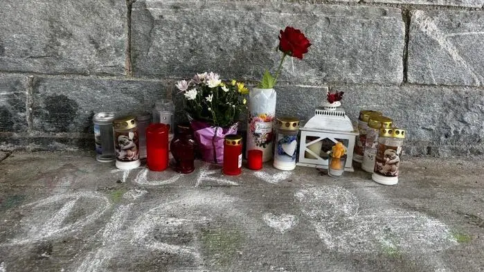 Kerzen und Blumen erinnern an die Frau