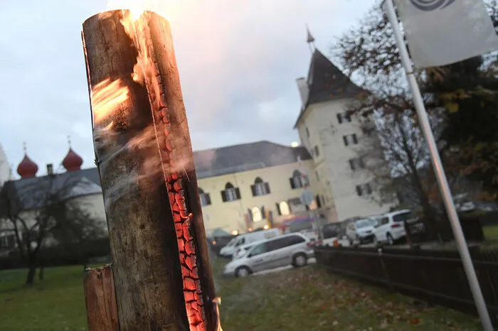 Feuriger, romantischer Wegweiser in der Dämmerung für die vielen Gäste zur alten Fischhalle im Stift Millstatt.