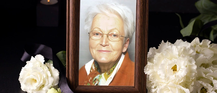 Eine grauhaarige Frau schaut in die Kamera