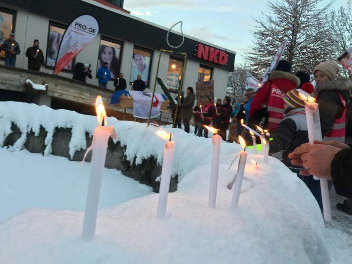 Kerzen im Schnee gegen Vorgangsweise des US-Konzern
