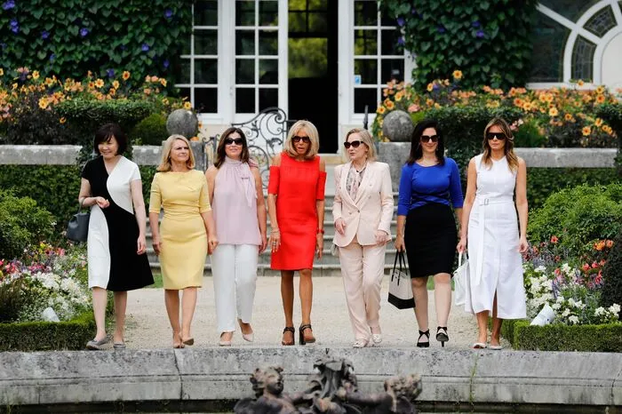 Die Ladies nehmen Aufstellung: Akie Abe (Japan), Malgorzata Tusk (EU), Jenny Morrison (Australien), Brigitte Macron (Frankreich), Cecilia Morel (Chile), Adele Malpass (Weltbank) und Melania Trump (USA).