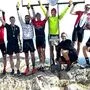 Die erfolgreichen Mountainbiker jubeln beim Gipfelkreuz auf der Hohen Rannach