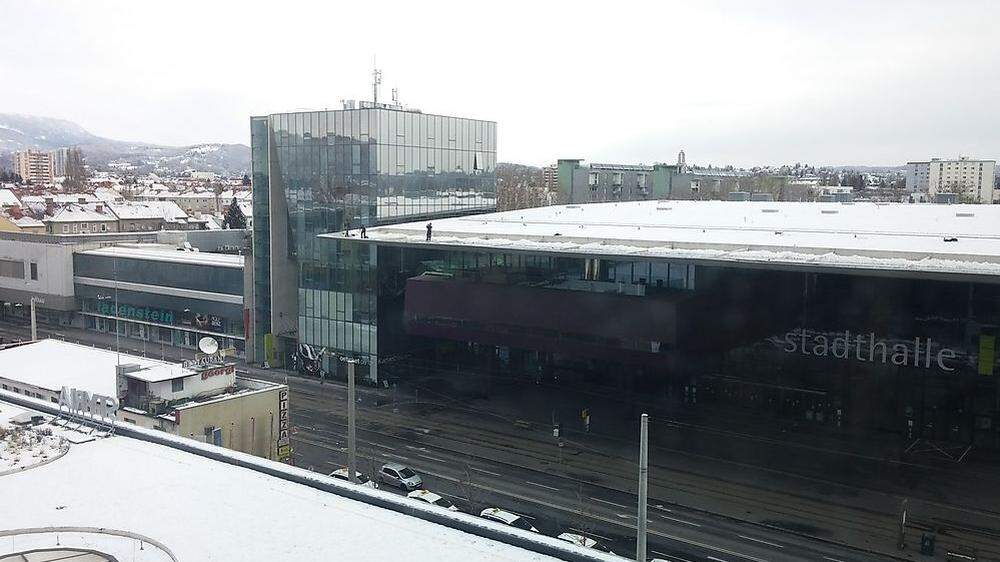 Schneeschaufeln am Dach der Stadthalle