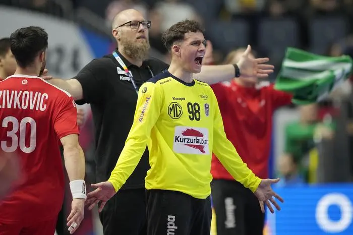 Austria's goalkeeper Constantin Moestl, right, reacts in front of Austria's head coach Ales Pajovic during the Handball European Championship main round match between Austria and Iceland in Cologne, Germany, Wednesday, Jan. 24, 2024. (AP Photo/Martin Meissner)