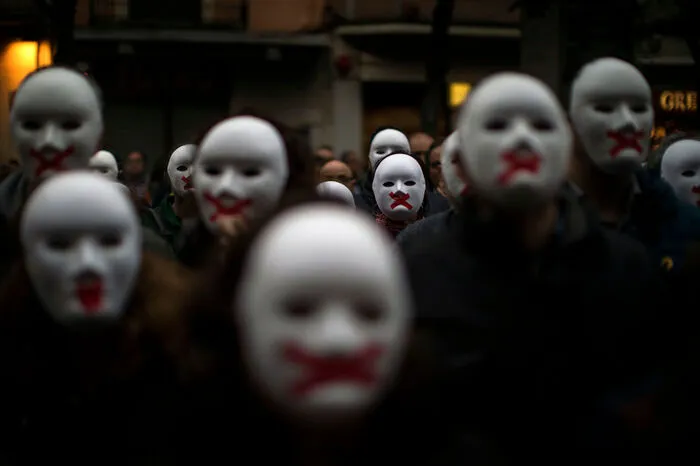 Menschen tragen weiße Masken, um ihre Solidarität mit den katalanischen Gefangenen auszudrücken.