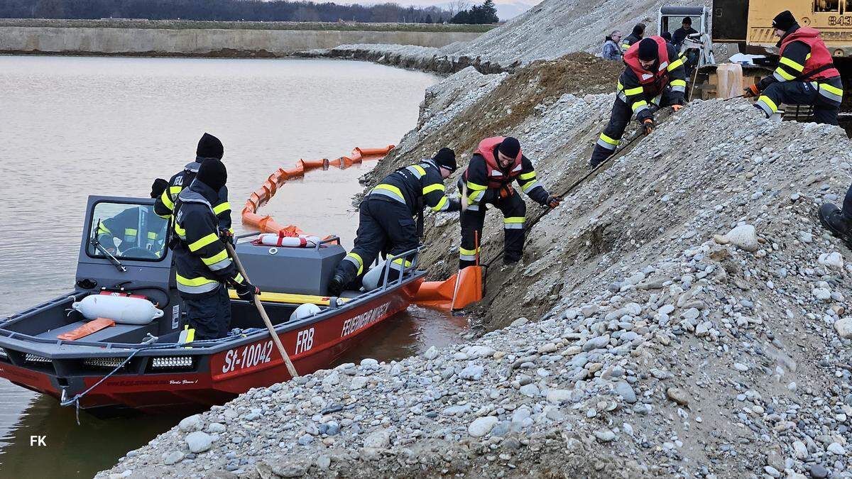 Mit einem Boot zogen die Feuerwehrmitglieder eine Ölsperre auf