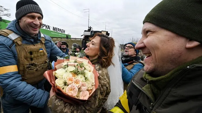 Inmitten des russischen Angriffskriegs gibt es in der Ukraine auch wenige schöne Momente.  Eine Soldatin und ein Soldat haben an einem Checkpoint nahe der Front in Kiew geheiratet. Bürgermeister Klitschko brachte Blumen.