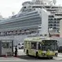 A bus carrying the passengers from the quarantined Diamond Princess cruise ship leaves a port in Yokohama, near Tokyo, Wednesday, Feb. 19, 2020. Passengers tested negative for COVID-19 started disembarking Wednesday. (AP Photo/Eugene Hoshiko)