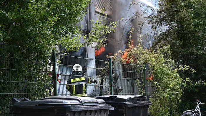 Völlig zerstört wurde ein Wohncontainer einer Flüchtlingsunterkunft bei einer Explosion. Ein Mensch starb, ein Polizist wurde schwer verletzt