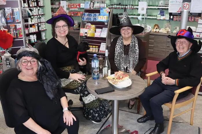 Den Umzug genossen manche auch aus ihren Fenstern oder – wie die Familie Emmerich – vom Inneren der Apotheke aus. Sie ließen es sich bei Sekt und Brötchen gut gehen.