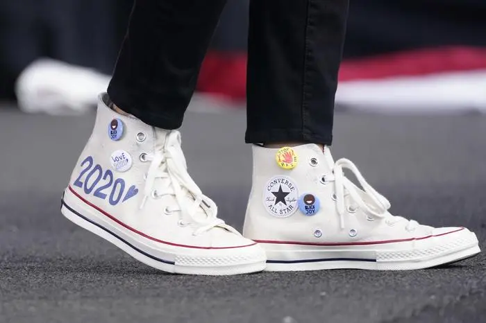 Converse high-top sneakers of Democratic vice presidential candidate Sen. Kamala Harris, D-Calif., are shown as she speaks at a drive-in early voting event, Saturday, Oct. 31, 2020, in Miami, Fla. Harris has landed on the cover of the February 2021 issue of Vogue magazine, but her team says there's a problem: the shot of the country's soon-to-be No. 2 leader isn't what both sides had agreed upon. Instead of the powder blue power suit Harris wore for her cover shoot, the first African American woman elected vice president is instead seen in more casual attire and wearing Converse Chuck Taylor sneakers, which she sometimes wore on the campaign trail. (AP Photo/Wilfredo Lee, file)