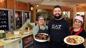 Maria Bubici, Antonio di Perna und Marina Mayro (von links) mit einer Izza Loredana mit Rinder-Pastrami, Rucolacreme und Mozzarella (um 13 Euro) und einer Pinsa di Mare mit Meeresfrüchten (um 16 Euro), die nach nur vier Minuten superfrisch und heiß aus der Küche kamen
