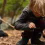 Nahaufnahme von einem im Wald spielenden Kind | Waldkindergärten erfreuen sich in Österreich wachsender Beliebtheit. Die Kinder werden hier großteils im Freien betreut