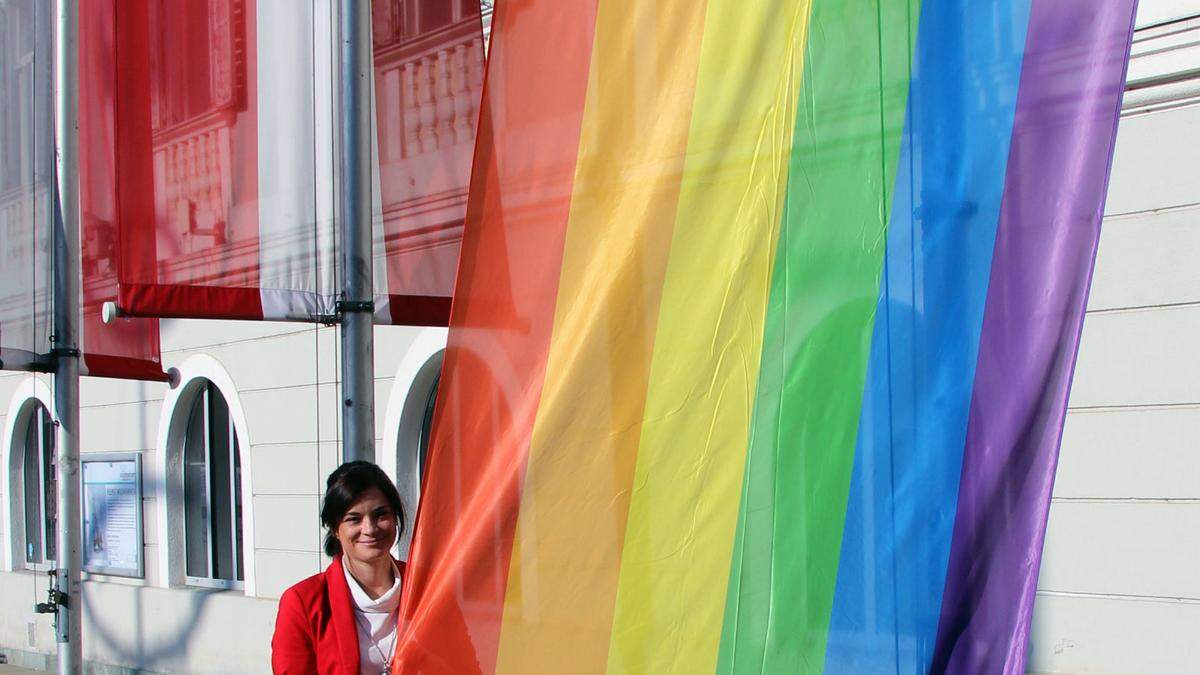 Stadträtin Corinna Smrecnik mit der Regenbogenflagge vor dem Rathaus