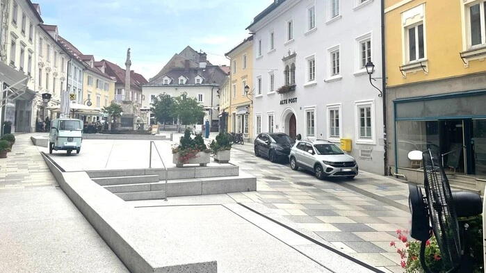 Am Bild sieht man die verschiedenen historischen Gebäude und viel Beton sowie Autos 